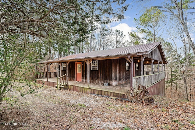 chalet / cabin with metal roof, board and batten siding, and a porch