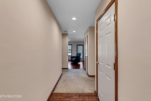 hallway with light carpet, recessed lighting, and baseboards