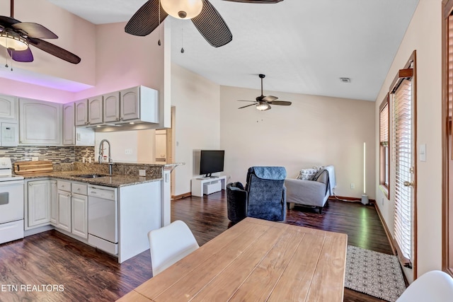 kitchen with open floor plan, white appliances, dark wood-style flooring, and light stone countertops