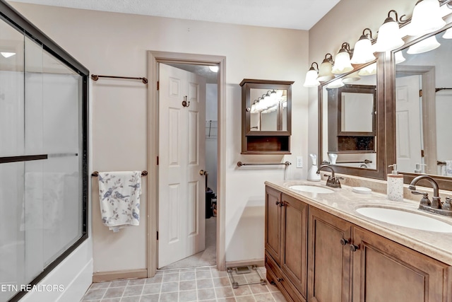 full bathroom with tile patterned flooring, double vanity, a shower with shower door, and a sink