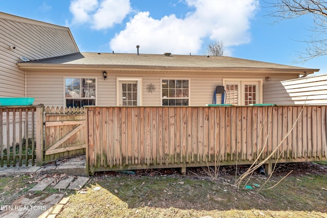 rear view of property featuring fence