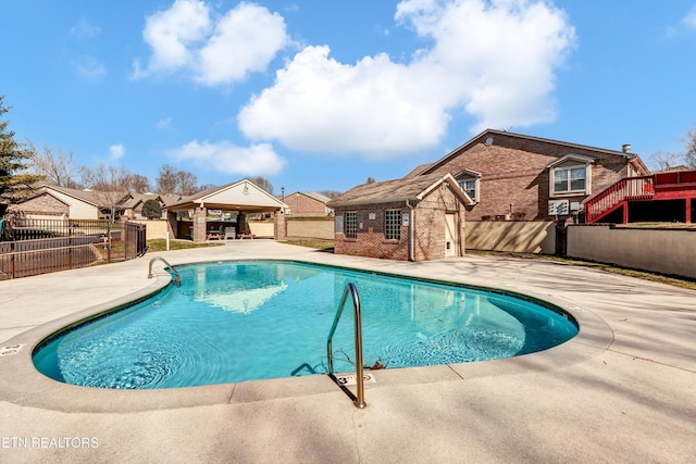 pool featuring a gazebo, a fenced backyard, an outbuilding, and a patio