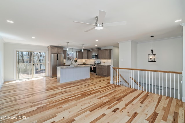 kitchen with light wood-type flooring, ornamental molding, appliances with stainless steel finishes, decorative backsplash, and ceiling fan