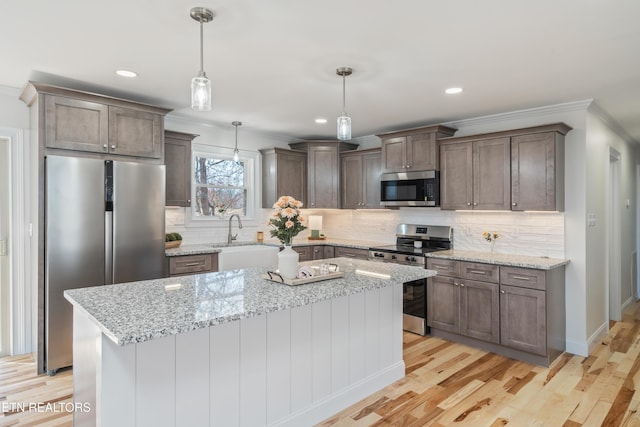 kitchen with a sink, stainless steel appliances, light wood-type flooring, and decorative backsplash