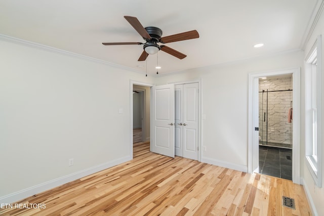 unfurnished bedroom featuring ornamental molding, wood finished floors, visible vents, and baseboards