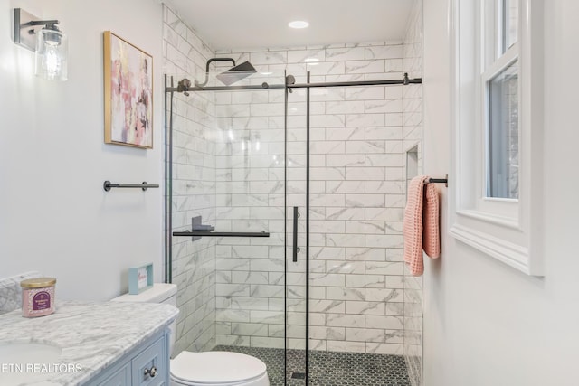 full bathroom featuring vanity, a shower stall, and toilet