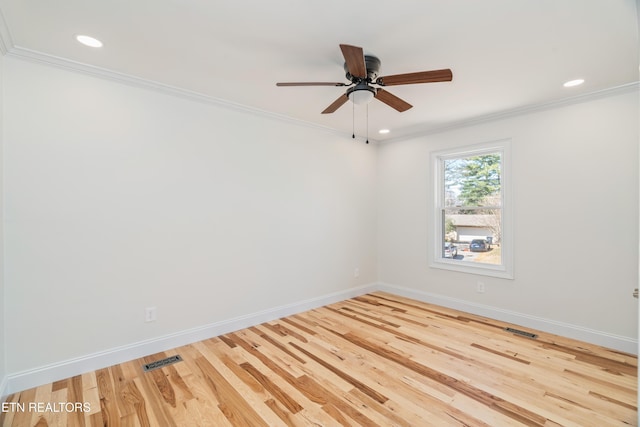 spare room featuring crown molding, wood finished floors, baseboards, and visible vents