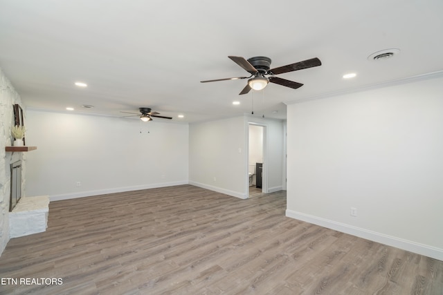 unfurnished living room with light wood-type flooring, baseboards, a ceiling fan, and crown molding