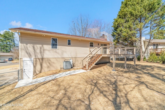 rear view of house with cooling unit, fence, a chimney, stairs, and a deck