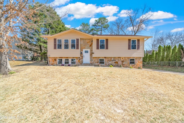 bi-level home with a front yard and fence