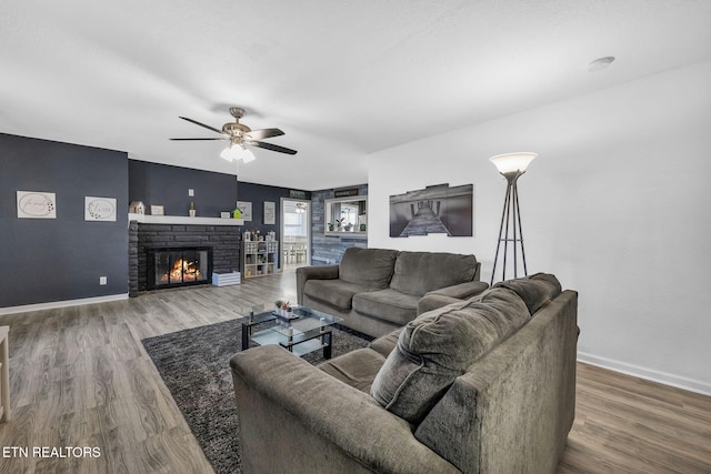 living room with a ceiling fan, wood finished floors, and baseboards
