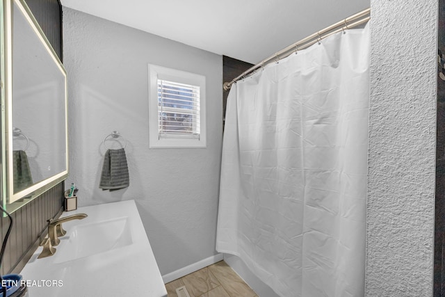 bathroom featuring vanity, a shower with curtain, and a textured wall