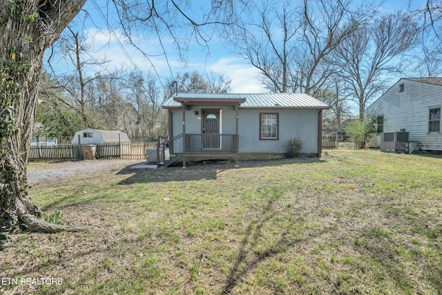 back of property featuring a standing seam roof, fence, a yard, cooling unit, and metal roof