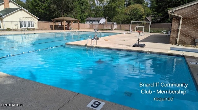 pool with a gazebo, a patio, and fence