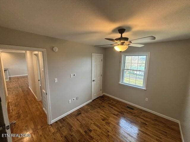 unfurnished bedroom with a textured ceiling, a ceiling fan, baseboards, and wood finished floors