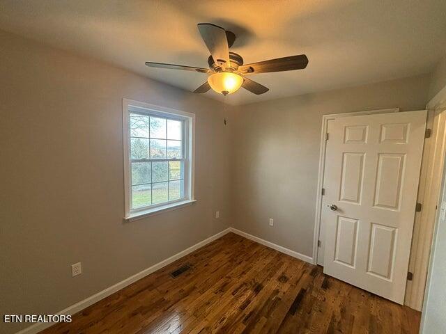 unfurnished bedroom featuring visible vents, a ceiling fan, baseboards, and wood finished floors