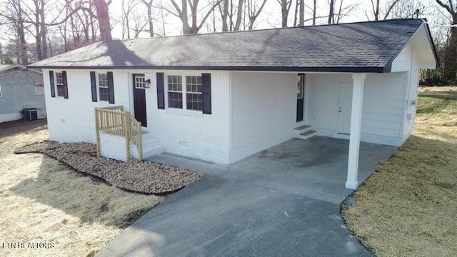 ranch-style house with brick siding, roof with shingles, central AC unit, crawl space, and driveway