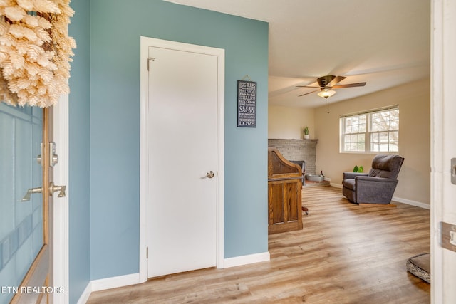 interior space with light wood-style floors, baseboards, and ceiling fan
