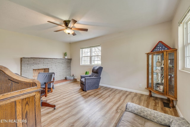 living area with ceiling fan, baseboards, visible vents, and wood finished floors