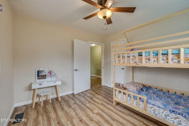 bedroom with visible vents, wood finished floors, baseboards, and ceiling fan