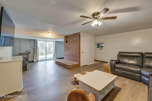 living area with a ceiling fan, baseboards, and wood finished floors