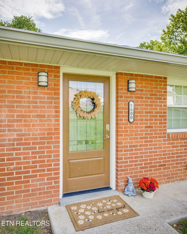 view of exterior entry featuring brick siding