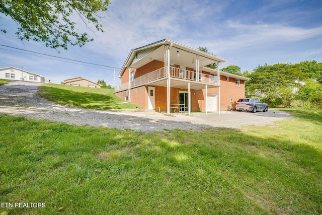 back of house featuring a lawn and driveway