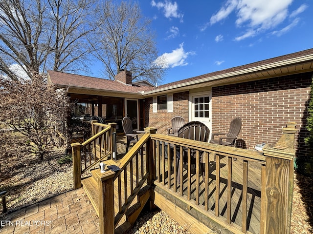 exterior space with brick siding, outdoor dining space, a patio area, and a chimney