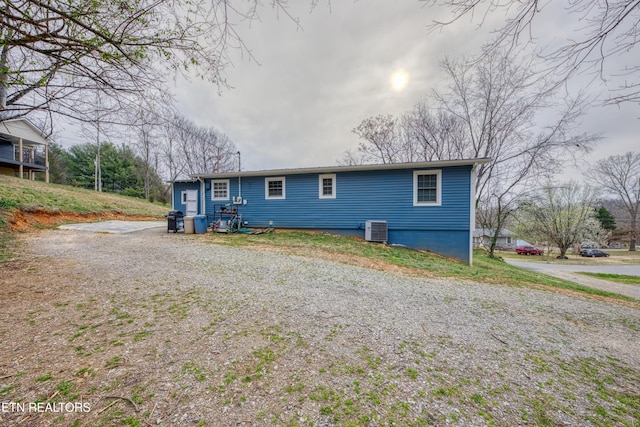 back of property featuring driveway and central AC