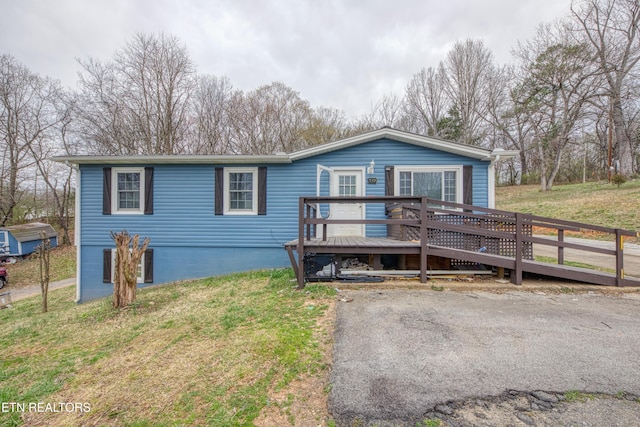 view of front facade with a deck and a front yard