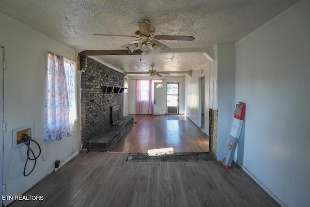 unfurnished living room featuring a fireplace, a textured ceiling, crown molding, and wood finished floors