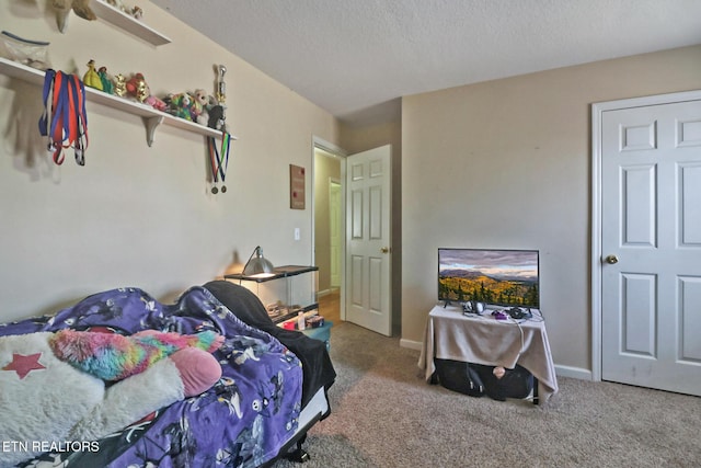 carpeted bedroom featuring a textured ceiling and baseboards