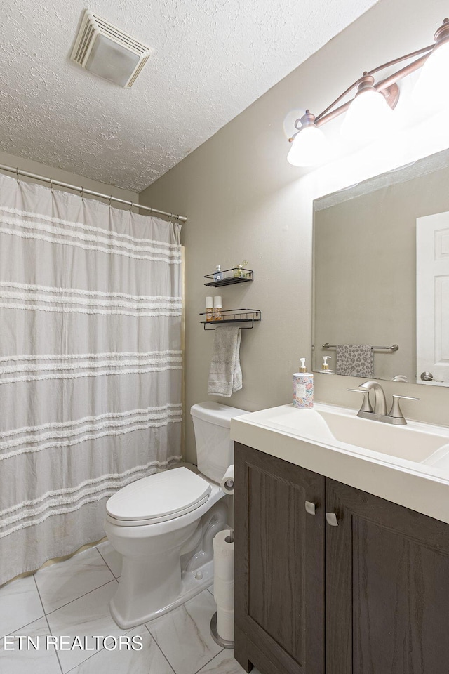 bathroom featuring visible vents, toilet, vanity, a shower with shower curtain, and a textured ceiling