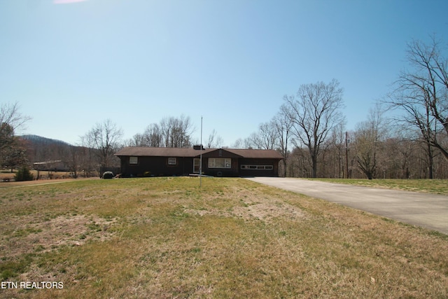 ranch-style home featuring a garage, a front lawn, and driveway