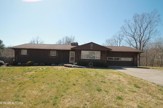 ranch-style home featuring a front yard, an attached garage, and driveway