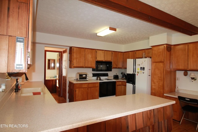 kitchen with black microwave, brown cabinets, white fridge with ice dispenser, electric range, and a sink