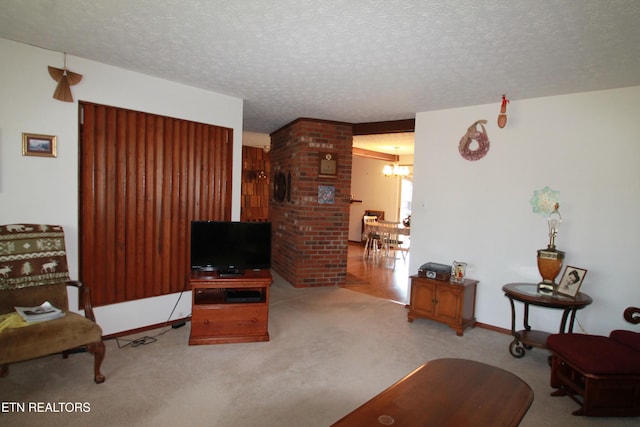 carpeted living area with a notable chandelier, a textured ceiling, and baseboards