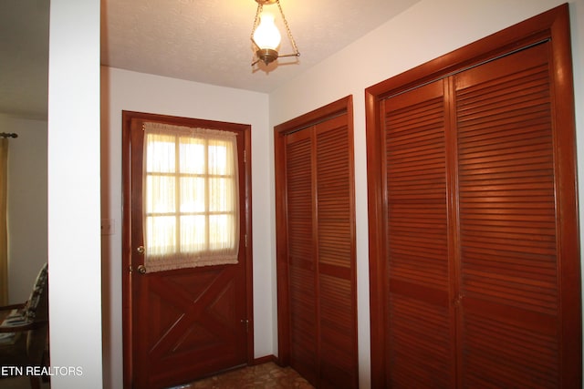 doorway to outside with a textured ceiling