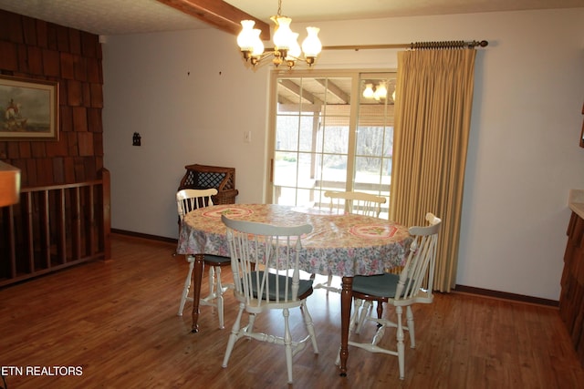 dining room featuring baseboards, an inviting chandelier, and wood finished floors