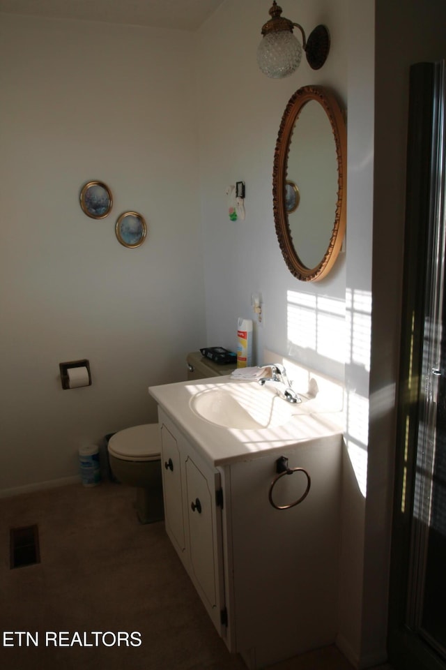 bathroom featuring vanity, toilet, and visible vents