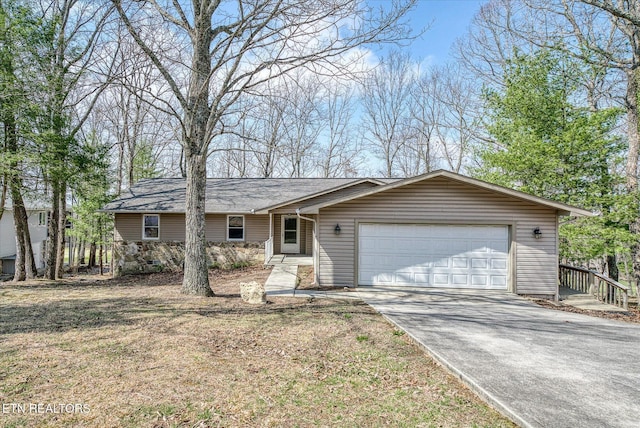 ranch-style home featuring stone siding, an attached garage, and concrete driveway