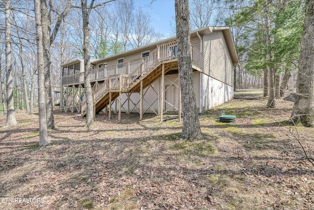 rear view of property featuring a deck and stairs