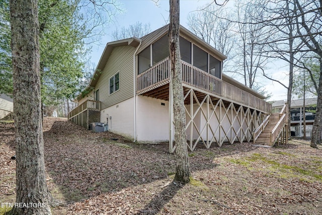 back of house with a deck, stairway, and a sunroom