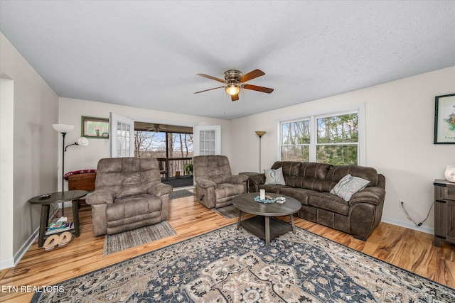 living area featuring a healthy amount of sunlight, ceiling fan, and wood finished floors