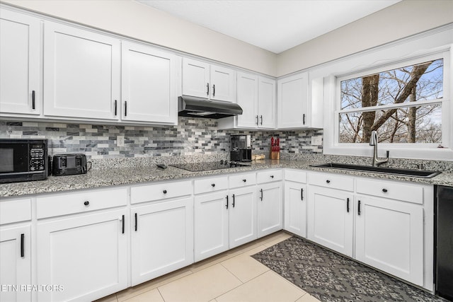 kitchen with a sink, decorative backsplash, black appliances, under cabinet range hood, and white cabinetry