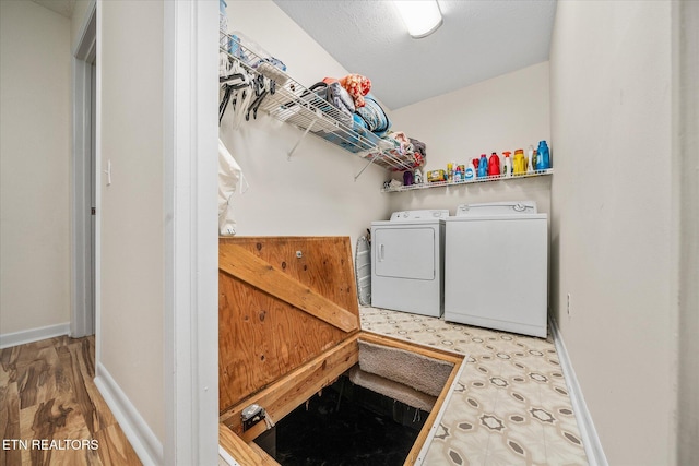 laundry area with laundry area, baseboards, and washing machine and clothes dryer