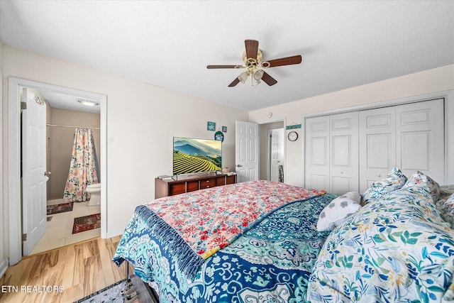 bedroom featuring a ceiling fan, ensuite bath, light wood-style floors, and a closet