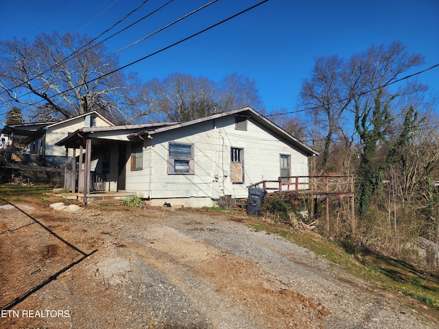 view of side of property with dirt driveway