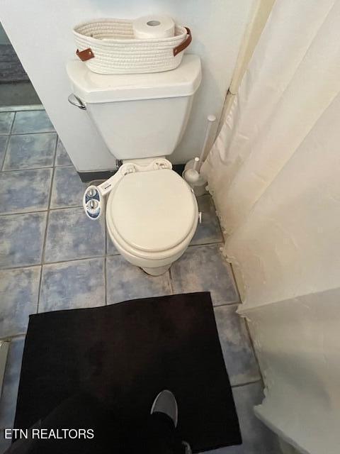 bathroom featuring tile patterned flooring and toilet