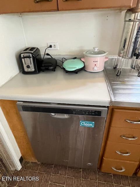 interior details featuring brown cabinets, dishwasher, and light countertops